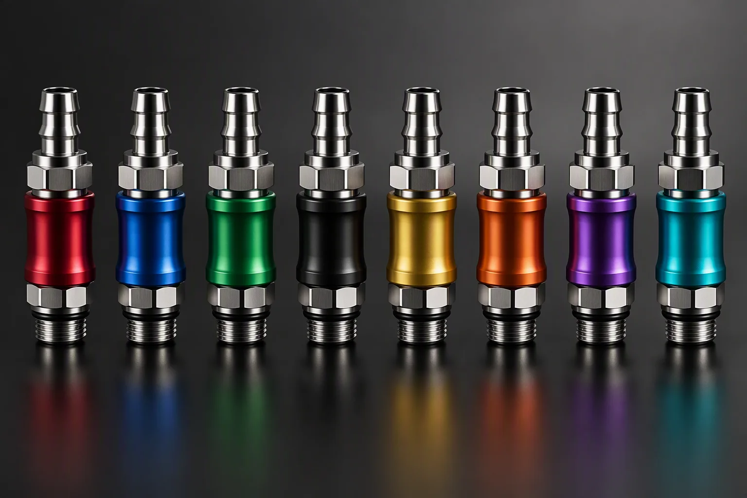 Stainless quick-disconnect couplings with coloured anodised rings laid out on a dark plate