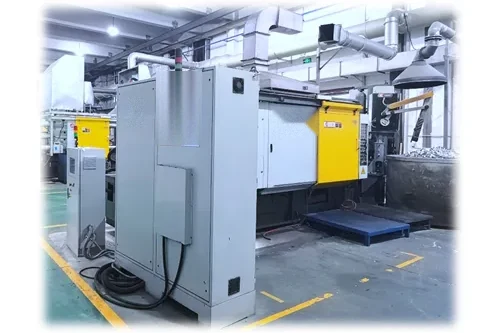 A die-casting cell seen at floor level: the machine base and a steel pallet on a marked floor